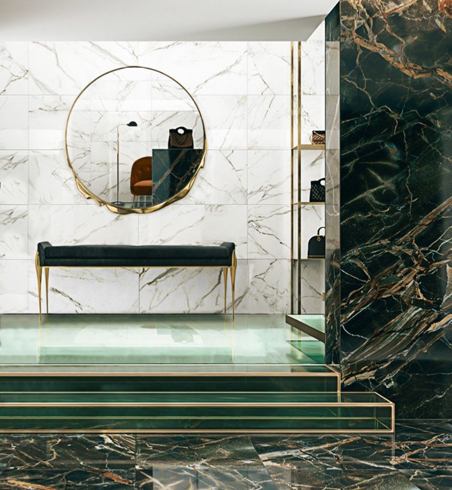 Dressing Rooms, green marble dressing room with gold details, a round gold mirror and a long black bench.