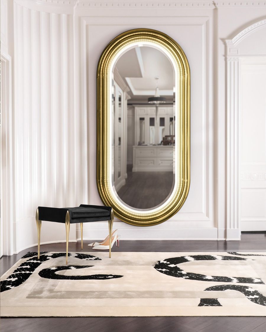 Dressing Rooms, gold mirror and small black bench, complimented by a white rug with snake imprint