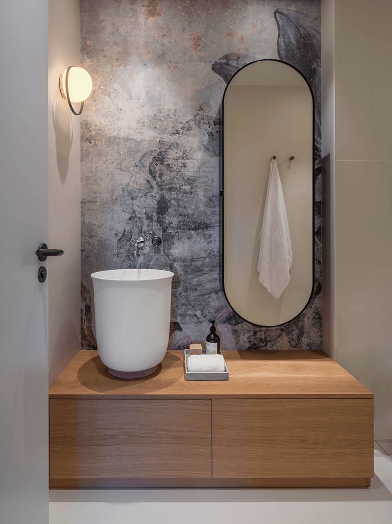 bathroom with white sink and oval wall mirror