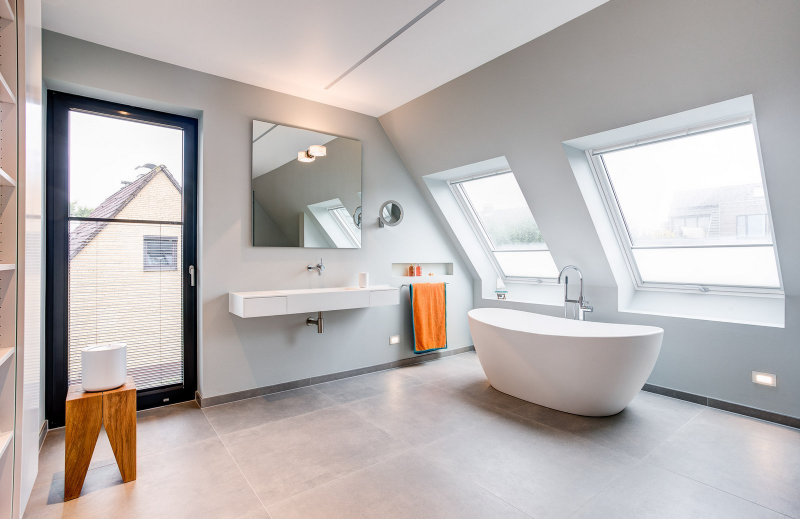 Bathroom Interior Design from Innenarchitektur im Neubau eines Architektenhauses with a white bathtub, a singluar washbasin and a square mirror