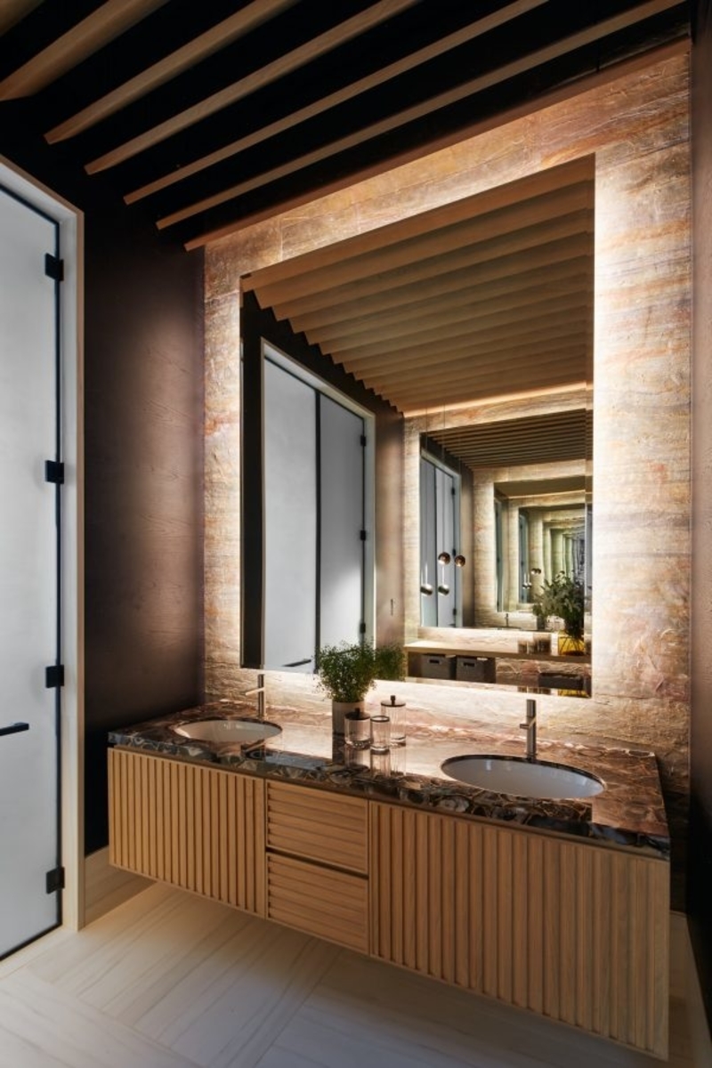 A bathroom furnished with a custom mirrors and custom washbasin.