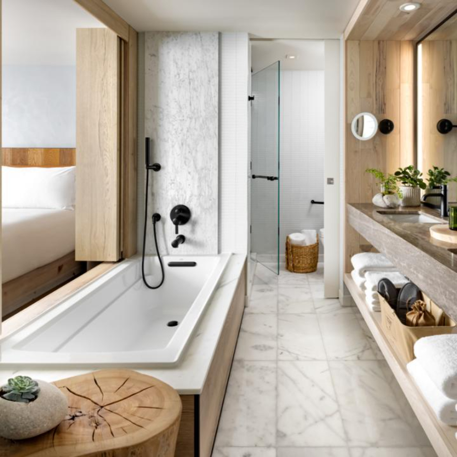 bathroom by Rockwell Group with white bathtub and wooden details