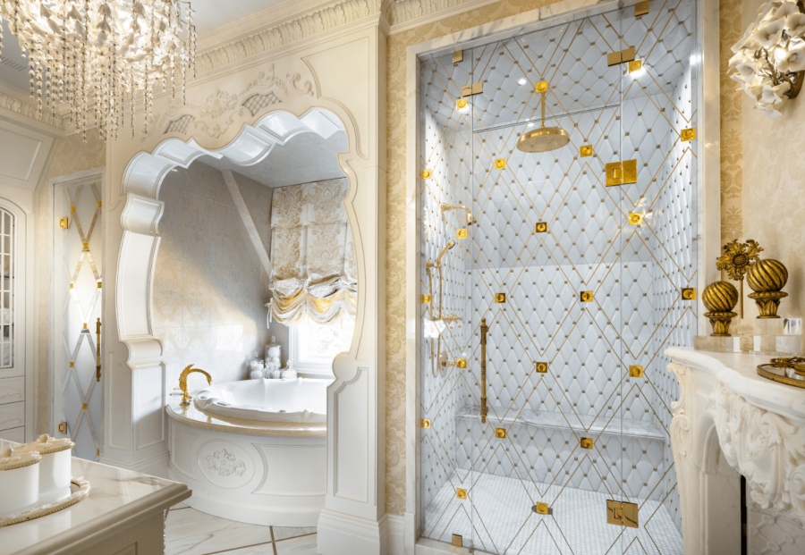 Luxury bathroom by Lori Morris Design. This white bathroom has a round big bathtub in white, a walk-in shower with gold details and a vanity table in white.