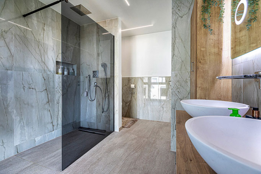 Wohnkonzepte Markus Wallner GmbH, Platz für die Familie bathroom with green marble, 2 sinks an wood flooring