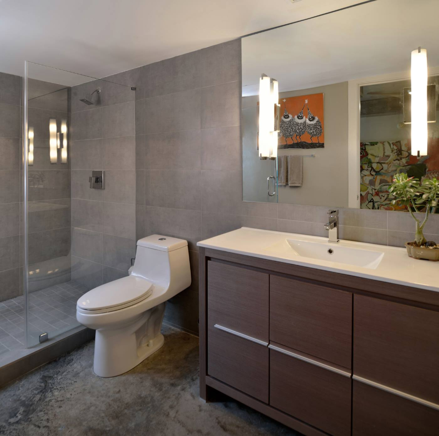 Bathroom Interior Design From Amilee Wendt. A wide bathroom in gray tones. There are two wall lights on the mirror.