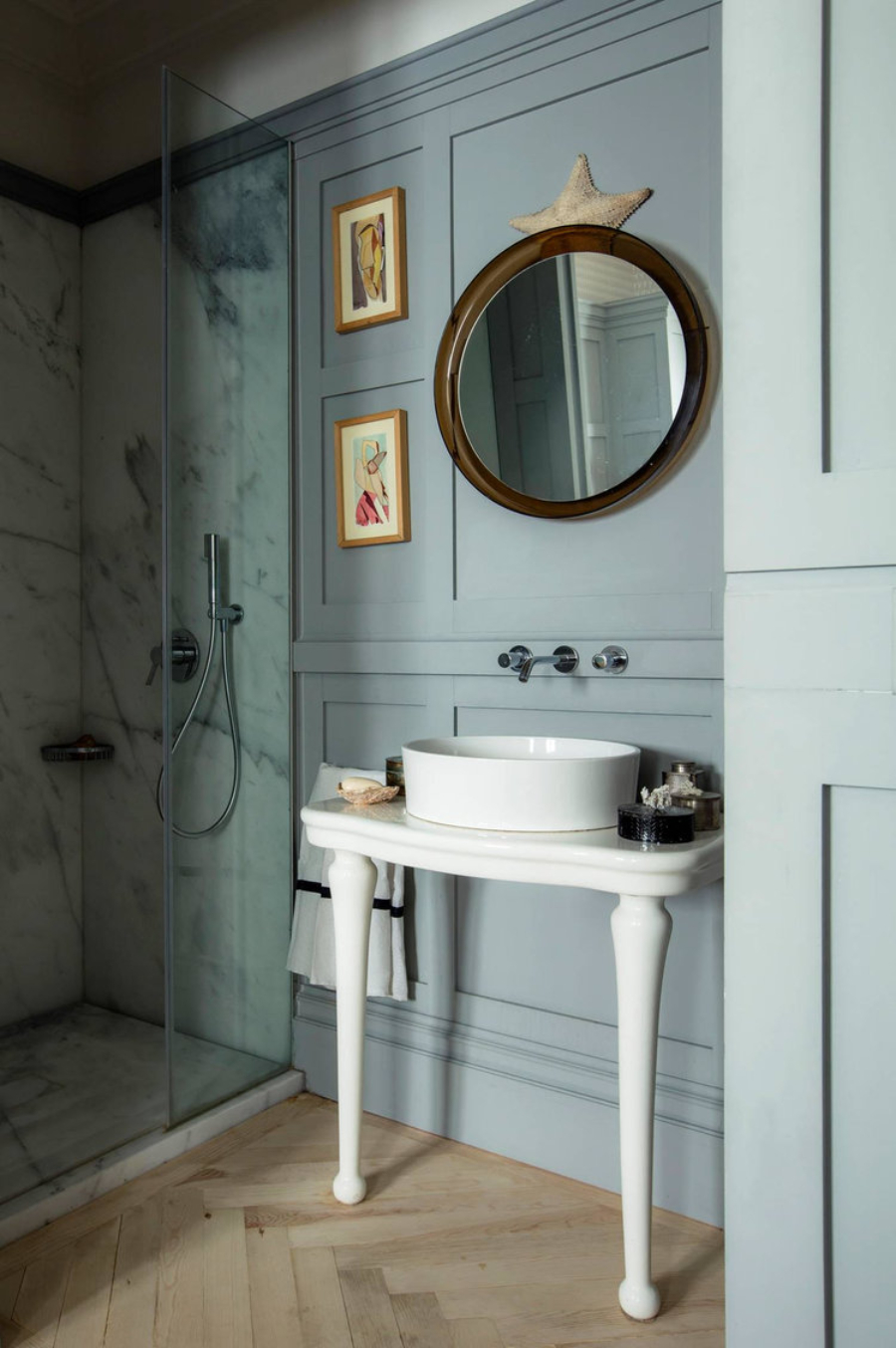 bathroom by Pepe Leal with white sink and round wall mirror