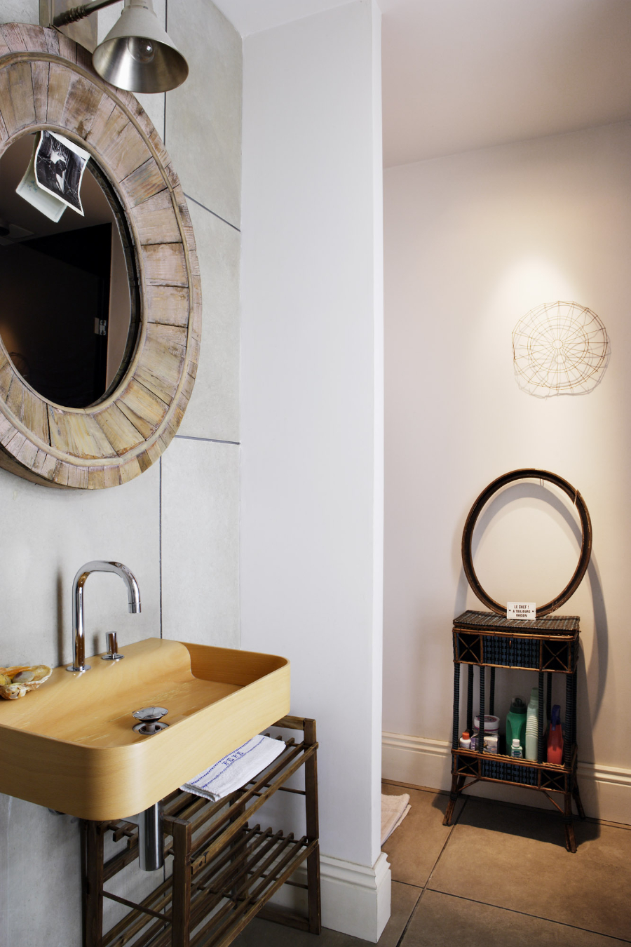 bathroom by Pepe Leal with wooden sink and round wall mirror