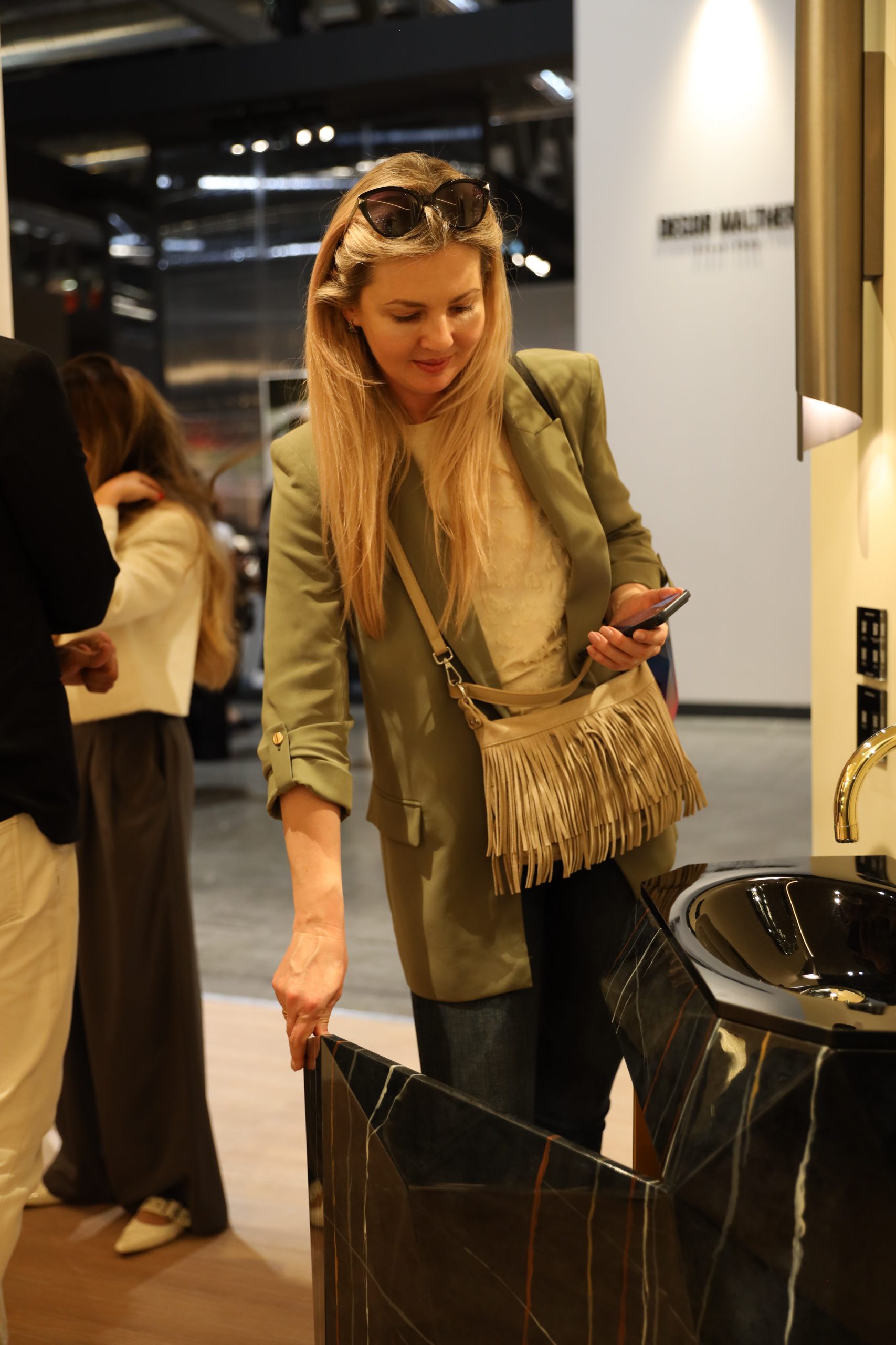 Visitor admiring Maison Valentina freestanding marble washbasin at iSaloni 2026