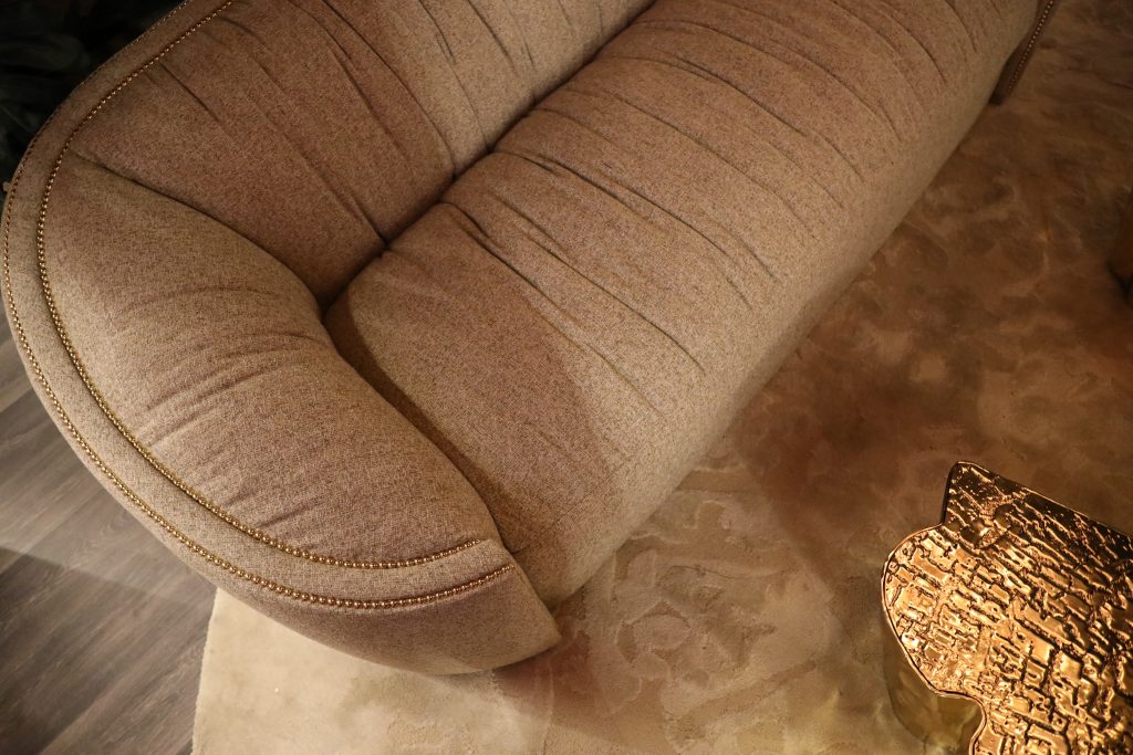 Home Society luxury curved sofa with gold nailhead trim detail at Milan Design Week 2026