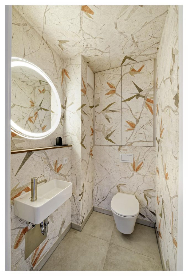 Heerwagen- Design Consulting TERRASSENWOHNUNG NEUPASING service bathroom, it is decorated with a white wallpaper with branches designed in it.