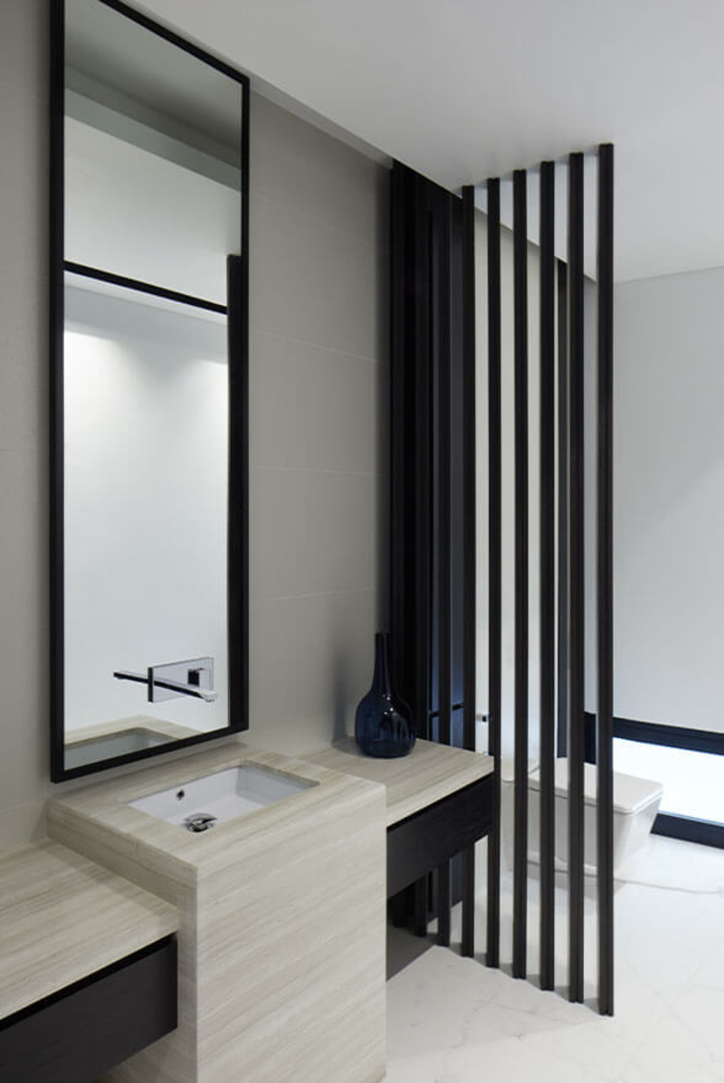 A bathroom decorated furnished with a custom wall mirror and a custom washbasin.