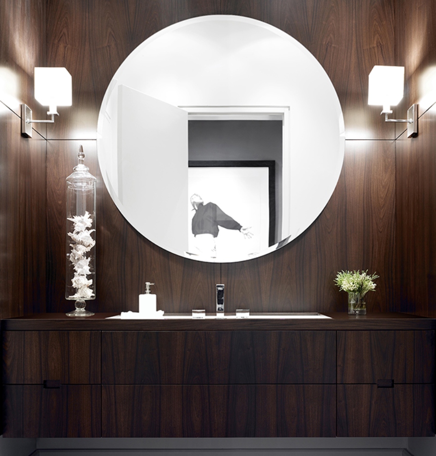 Ideas to decorate bathroom from Julie Charbonneau. This bathroom in wood walls has a round mirror and a vanity also in wood.