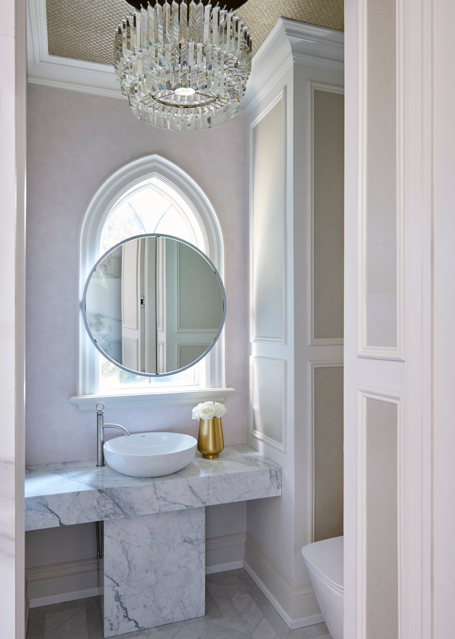 Bathroom design ideas from Stacey Cohen Design. This modern bathroom has a vanity in white marble, a white sink and a round mirror in front of the window.